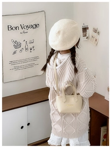 Sac seau crème pour enfants avec poignée et bandoulière porté par un petit mannequin