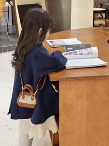 Mini shell-shaped crossbody bag for girls styled with casual blue jacket lifestyle view