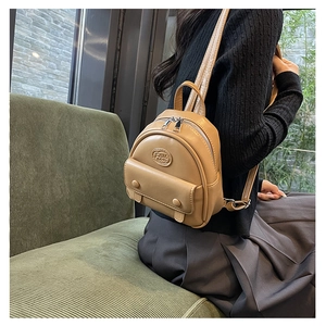 Detailansicht des khakifarbenen Mini-Rucksacks aus PU-Leder mit geprägtem Logo und Reißverschluss