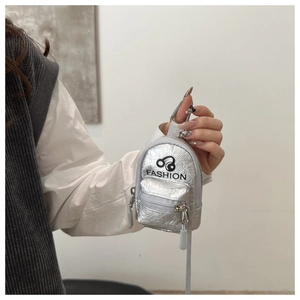 Close-up of mini silver backpack coin purse featuring headphone graphic and metal hook
