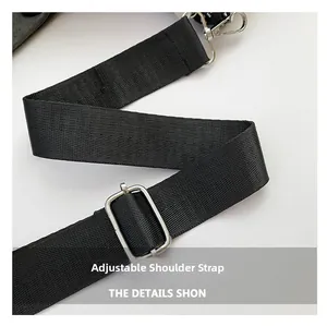 Dettaglio della tracolla regolabile in nylon nero con gancio e fibbia in metallo argento