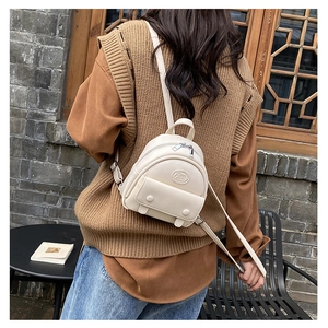Eleganter cremefarbener Mini-Rucksack mit Metallschnallen in Street-Style-Szene