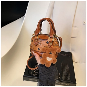 Détail du mini sac bandoulière marron avec imprimé ours et breloque en peluche