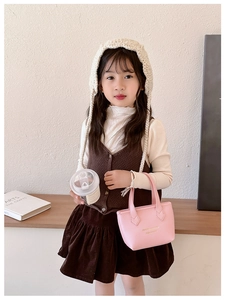 Détail du sac seau rose en cuir pour filles avec lettrage doré et tenue pour enfant