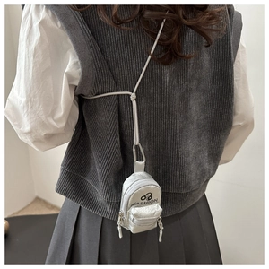 Close-up of a silver mini fashion backpack coin purse with metallic finish and lanyard
