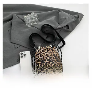 Dettaglio della borsa a secchiello leopardata con coulisse e telefono per scala