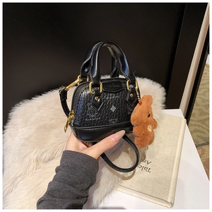 Détail du mini sac noir imprimé ours avec breloque peluche et fermetures éclair dorées