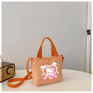 Detailed view of kids' cartoon bear canvas handbag with adjustable strap and pink heart print