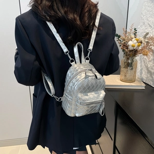 Silver woven mini backpack with Intrecciato pattern styled on a model in a modern room