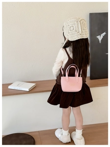 Sac seau rose en cuir PU pour filles avec poignée et bandoulière porté par une enfant
