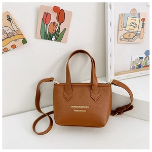 Détails du cuir grainé marron et du logo doré sur le mini sac à main fourre-tout