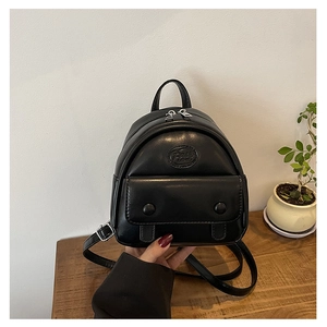 Detail eines Mini-Lederrucksacks in Schwarz mit Logo-Prägung und Reißverschluss