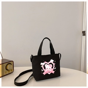 Detail of black canvas tote bag featuring a cute pink cartoon bear and heart print