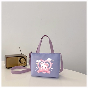 Close-up of purple cartoon bear handbag with pink hearts and adjustable shoulder strap