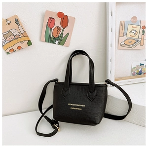 Détail du mini sac seau en cuir noir grainé avec lettrage doré et bandoulière réglable