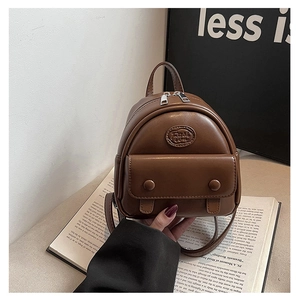 Details eines dunkelbraunen Mini-Rucksacks aus Leder mit silbernen Doppelreißverschlüssen