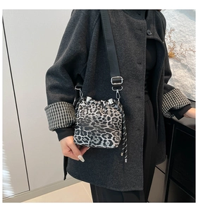 Dettaglio borsa a secchiello leopardata con chiusura a coulisse e tracolla per l'autunno