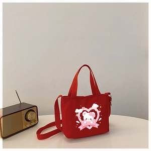 Detail of red canvas tote bag featuring a cute white bear and pink heart print design