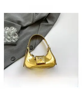 Close-up of golden metallic mirror finish mini handbag with silver bow detail