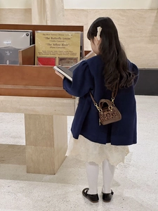 Girl wearing leopard print mini shell bag styled with a navy coat and lace skirt