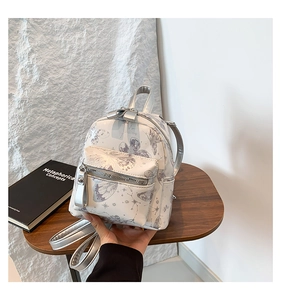 Detailansicht Mini-Rucksack aus silberweißem Kunstleder mit Schmetterlings- und Sternmuster
