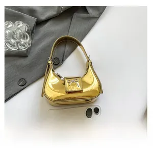 Macro detail of golden crescent hobo bag with metallic finish and silver bow accent