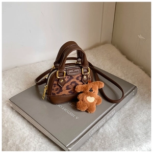 Detail shot of mini leopard print girl's handbag with brown plush bear accessory