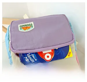 Detailed view of the colorful macaron-toned front pocket holding a small milk carton
