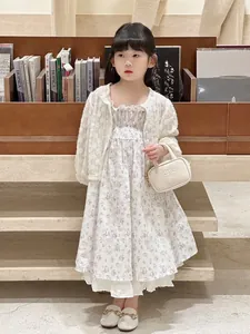 Detail of a young girl holding a white mini handbag with elegant lace floral summer dress