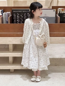 Toddler girl wearing stylish outfit with a small beige embossed handbag and floral dress