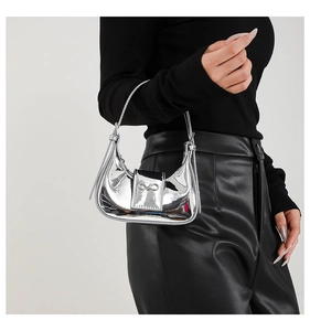 Close-up of a silver mirror-effect mini bag featuring a delicate metal bow detail