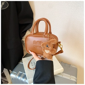 Brown mini bowling bag for kids with embossed letters and a cute plush bear charm