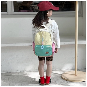 Detail of colorful patchwork kids backpack with zipper pockets and side mesh holder