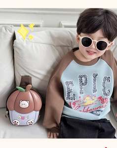 Détail d'un sac de poitrine pour enfant avec motif d'ours sur un canapé blanc