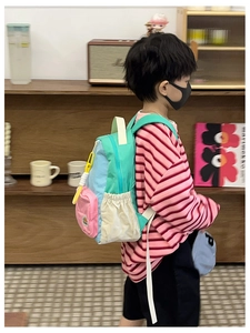 Detailed side view of colorful kids backpack with drawstring pocket and vibrant panels