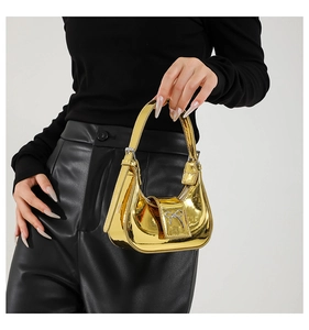 Detail of a shiny gold metallic mini handbag featuring a silver bow buckle and crescent design