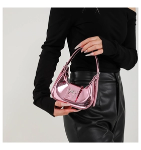 Close-up of metallic pink mini handbag with silver bow buckle in high-gloss finish