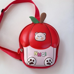 Détail du sac enfant en forme de pomme rouge avec ours mignon et feuille décorative