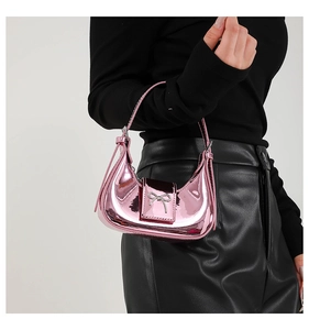 Detailed view of metallic pink crescent bag featuring silver bow accent and glossy finish