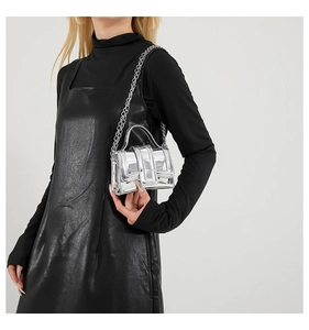 Mini sac à bandoulière argent miroir avec chaîne en métal porté par un mannequin