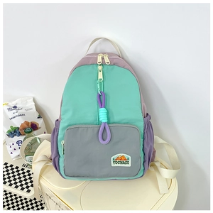 Detail view of the tricolor patchwork kids backpack featuring mint, grey and purple panels