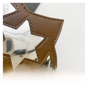 Détail macro du cuir découpé en étoile et surface miroir du sac bandoulière UFO