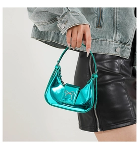 Detail of blue metallic mini bag featuring silver bow buckle and zip closure