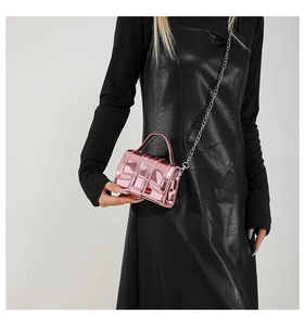 Detail of a mini pink metallic crossbody bag with mirror finish and silver chain strap