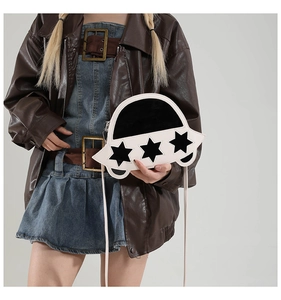 Sac bandoulière en forme d'OVNI porté avec veste en cuir au design créatif