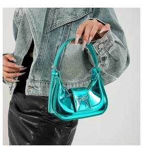 Detail of cyan metallic mini handbag featuring a silver bow and sleek hobo curve