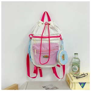 Detail of multi-color drawstring backpack with mountain logo and matching round coin purse