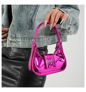 Detail of metallic pink y2k mini handbag featuring silver bow and embossed handle