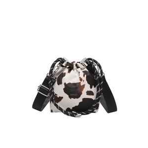 Mini cow print bucket bag with drawstring closure and stylish wide shoulder strap