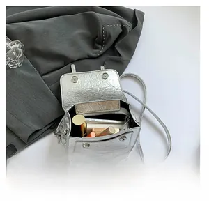 Interior view of silver crackle texture messenger bag showing capacity for phone and cosmetics